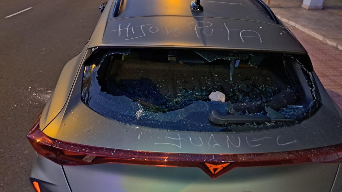 Un hombre rompe el cristal de un coche con una piedra