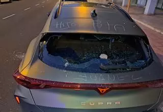 Un hombre rompe el cristal de un coche con una piedra