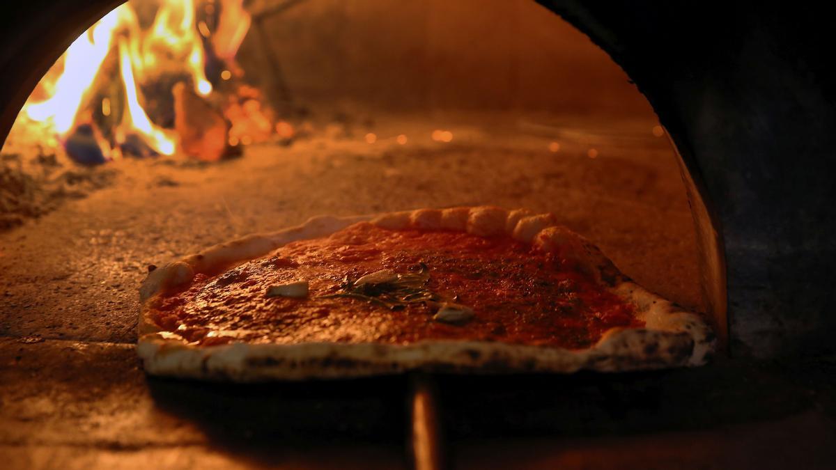 Una pizza saliendo del horno