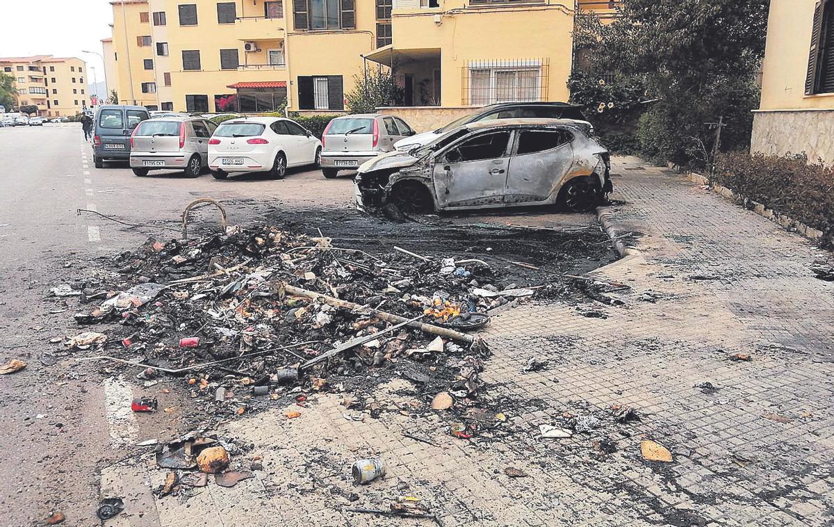 Restos de los contenedores y uno de los coches arrasados en la calle Santiago Álvarez Avellán.