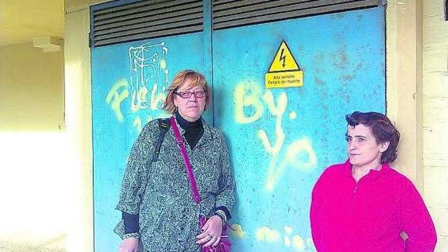 Maite Bastida y María Miramontes, vecinas de Sada, ante el transformador en el bajo de su edificio. / la opinión