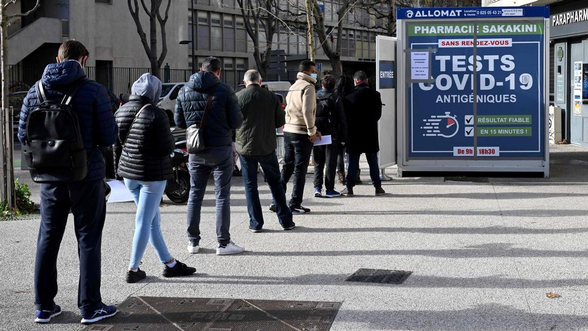 a gente hace cola frente a una farmacia para recibir pruebas antigénicas de covid- 19 el 10 de enero de 2022 en Marsella, sur de Francia, mientras los casos de covid- 19 se disparan en Europa . (Foto de )