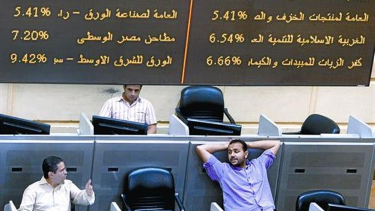 Dos corredores de bolsa charlan animadamente en el mercado de valores de El Cairo, ayer.