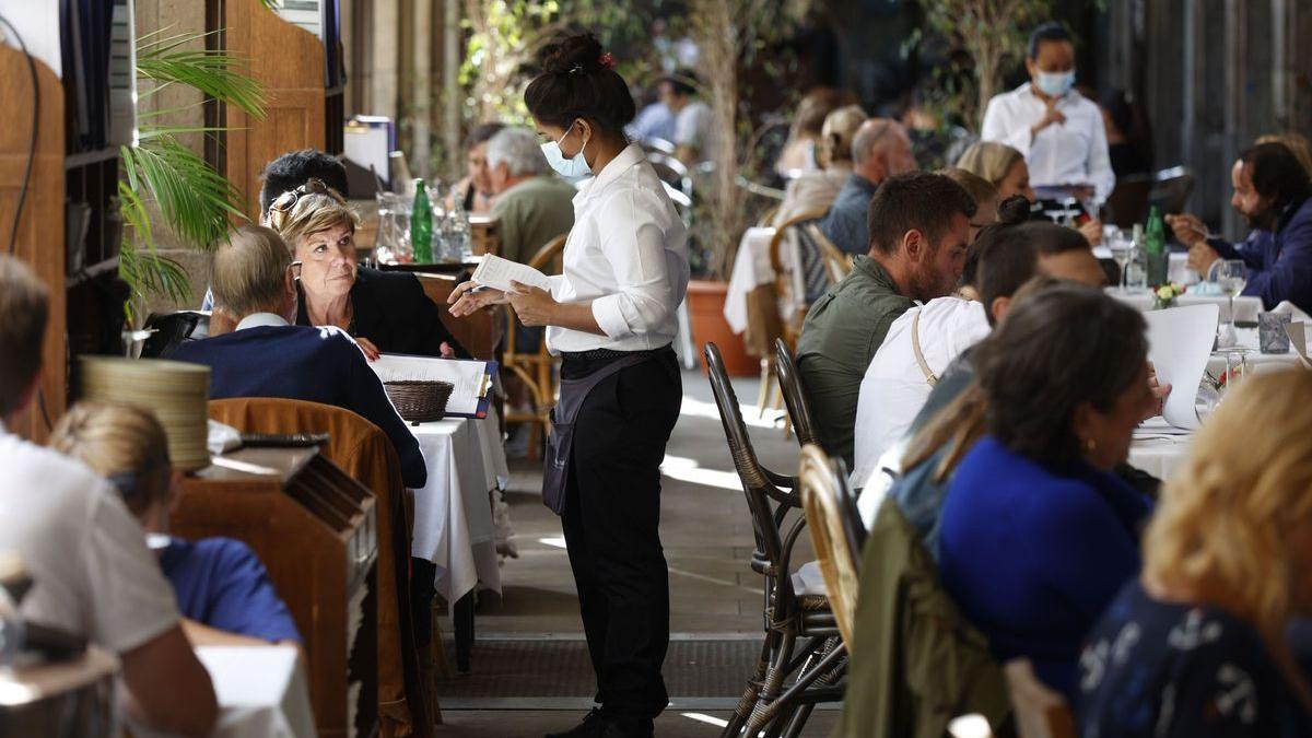 Una camarera atiende a los clientes de un restaurante.