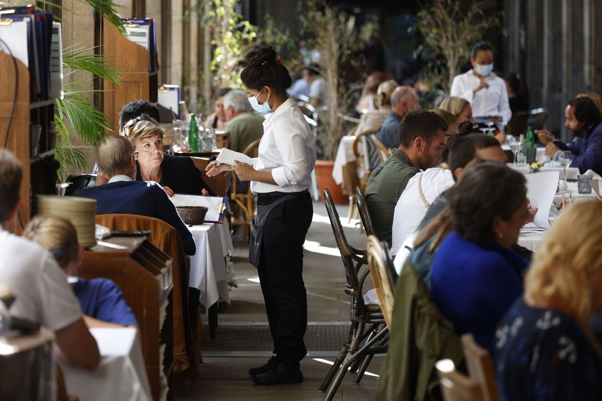 Una camarera atiende a los clientes de un restaurante.