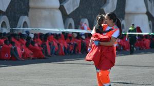 Una trabajadora de Cruz Roja recoge a un niño migrante en Canarias.