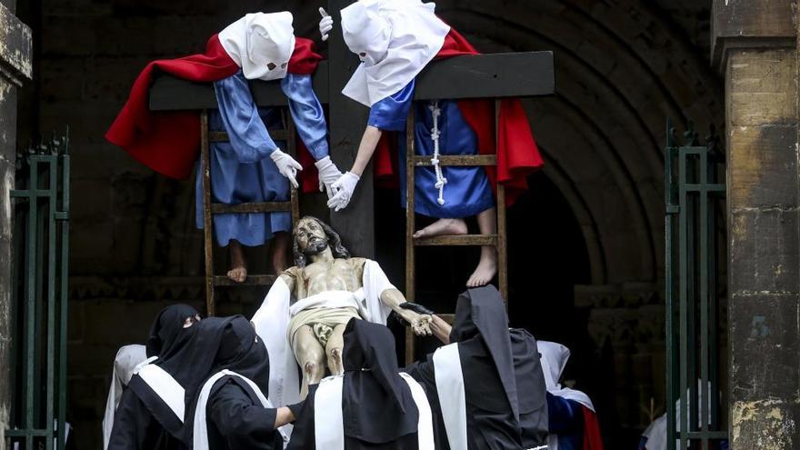 Dos sanjuaninos bajando al Cristo de la cruz antes de la procesión.