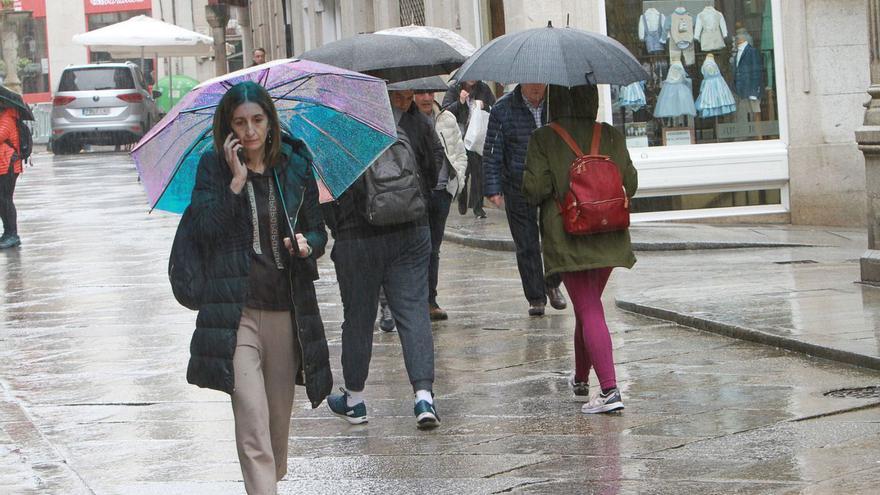 Una mujer camina por el centro de la ciudad, cubierta con paraguas, al igual que otros ciudadanos.   | // I.O.