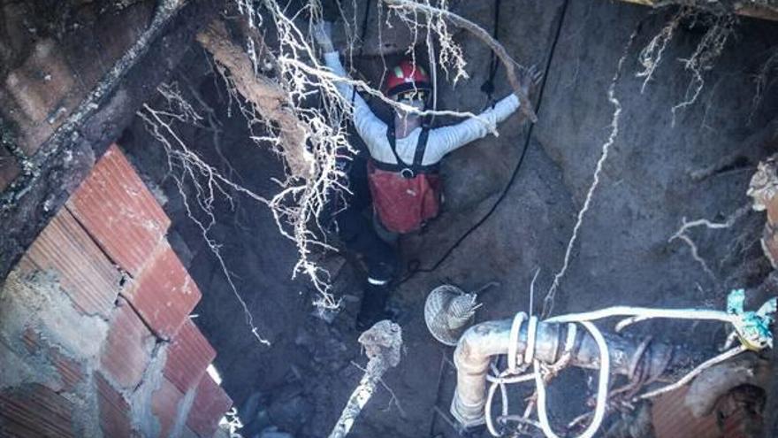 Un bombero en el pozo donde ayer cayó el hombre.