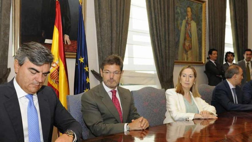 Jesús Sedano, en primer plano, firma el convenio en un acto presidido por Ana Pastor. Foto