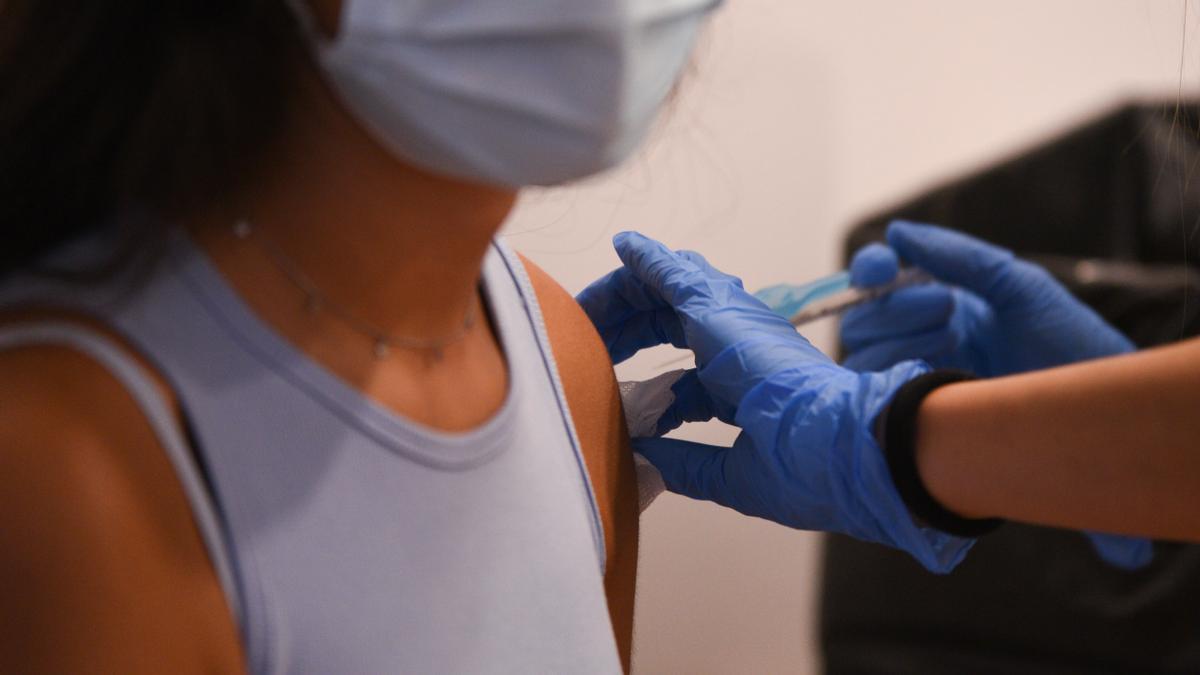 Una adolescente recibe la primera dosis de la vacuna Pfizer en un punto de vacunación