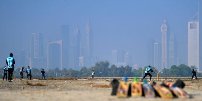 Trabajadores asiáticos juegan al críquet en su día libre en Dubai, ya que las autoridades del emirato del Golfo permitieron que se practicara deporte en áreas públicas los fines de semana, a pesar de las restricciones del coronavirus COVID-19.
