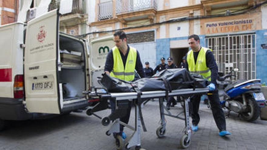 Los servicios funerarios sacan el cuerpo de la vivienda de la calle José Benlliure de Valencia.