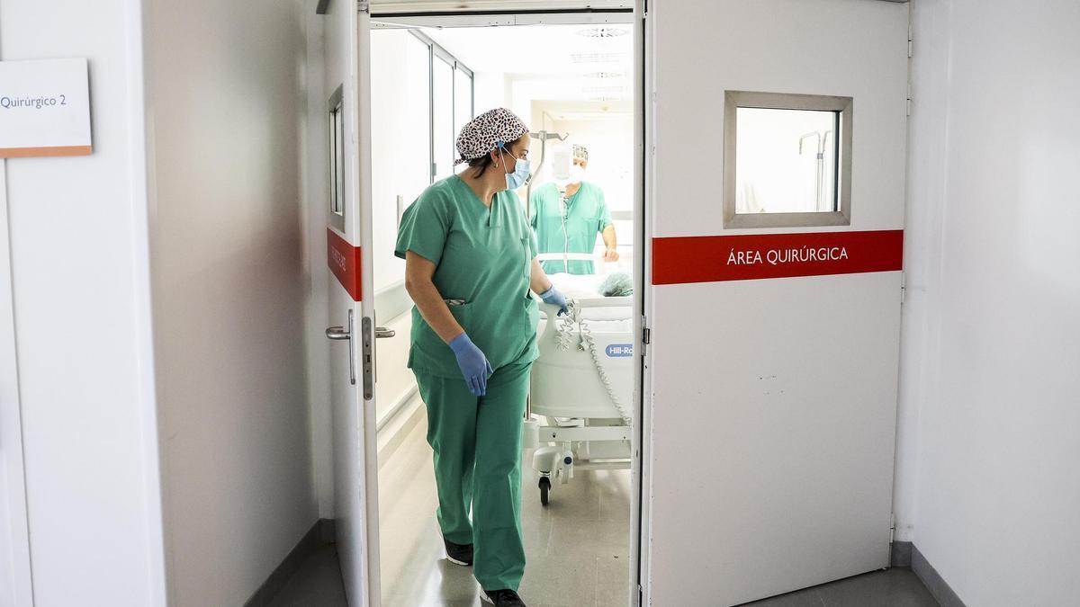 Dos celadores trasladan a un paciente en el HUCA.