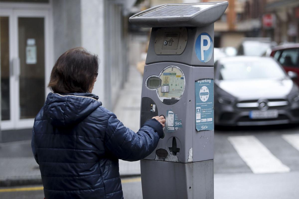 USUARIA DE LA ZONA AZUL UTILIZANDO UN PARQUIMETRO.