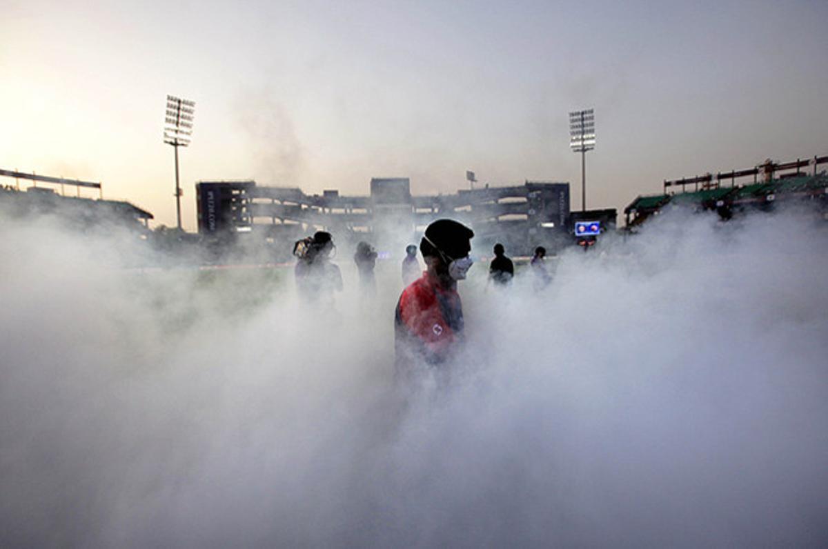 Un treballador fumiga un camp de criquet, abans d’un partit de la Lliga Premier de l’Índia (IPL) que disputaran el Delhi Daredevils i el Kings XI Panjab, a Nova Delhi.