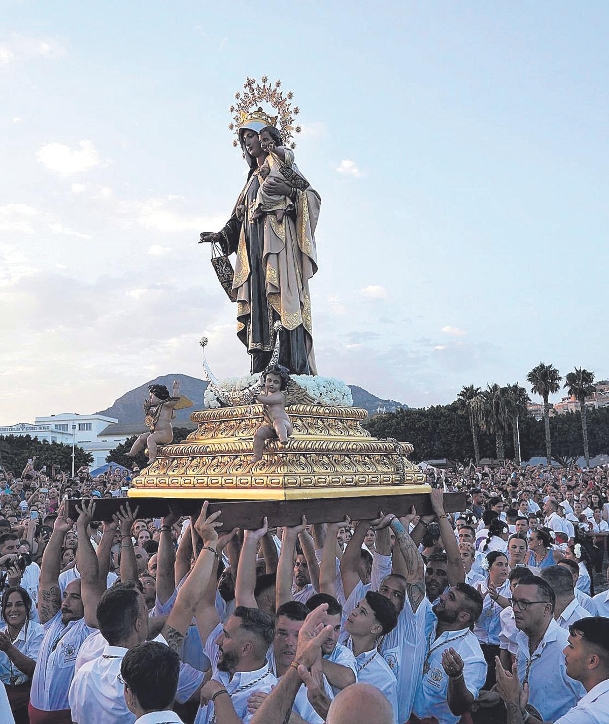 Tradicional procesión de la Virgen del Carmen por el barrio de El Palo, donde centenares de personas acompañan a los marengos a la imagen