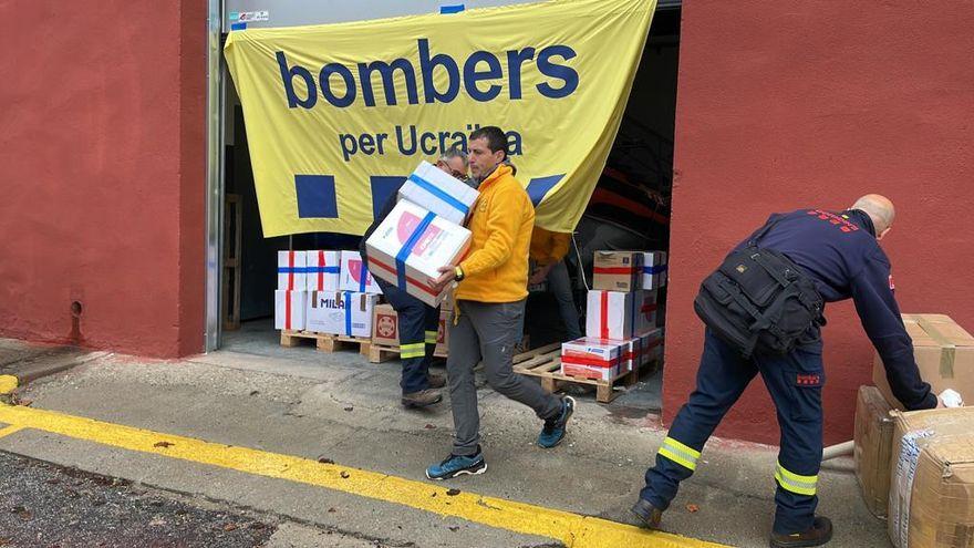 Bombers carregant material cap a les furgonetes