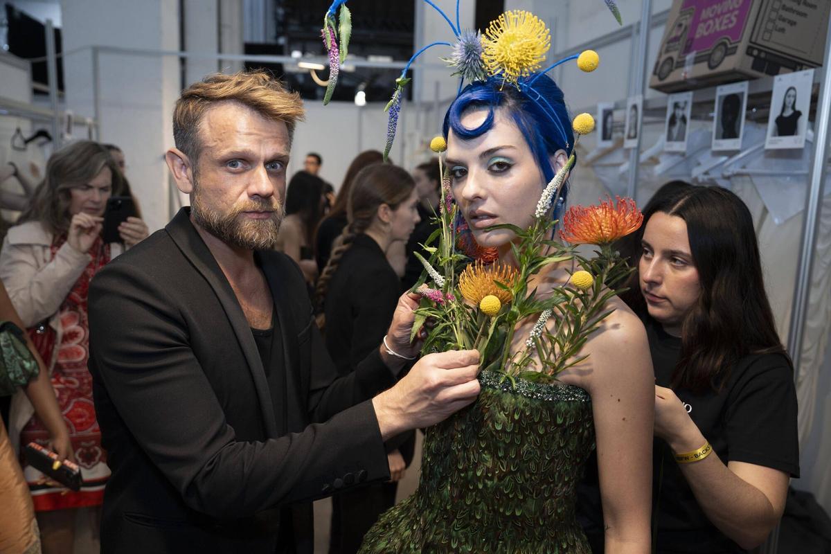 El diseñador Mariano Moreno, dando los últimos toques botánicos a la artista Sita Abellán, antes de su desfile en la Barcelona Bridal Fashion Week.