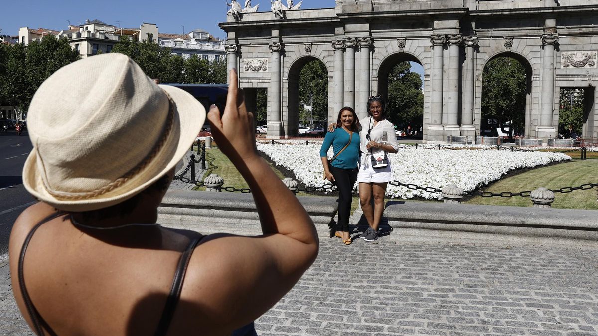 Turistas se fotografía frente a la Puerta de Alcalá, en Madrid.