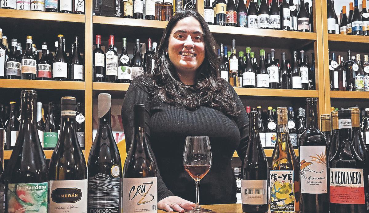 Chaxiraxi Triana Higuera entre algunos de los vinos que comercializa en su local del Mercado de Vegueta, en Las Palmas de Gran Canaria.