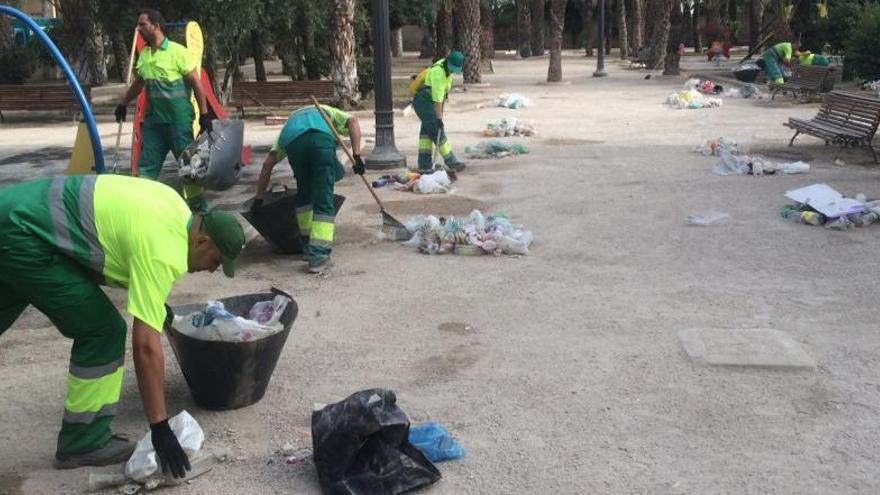 Operarios limpiando esta mañana una zona verde.