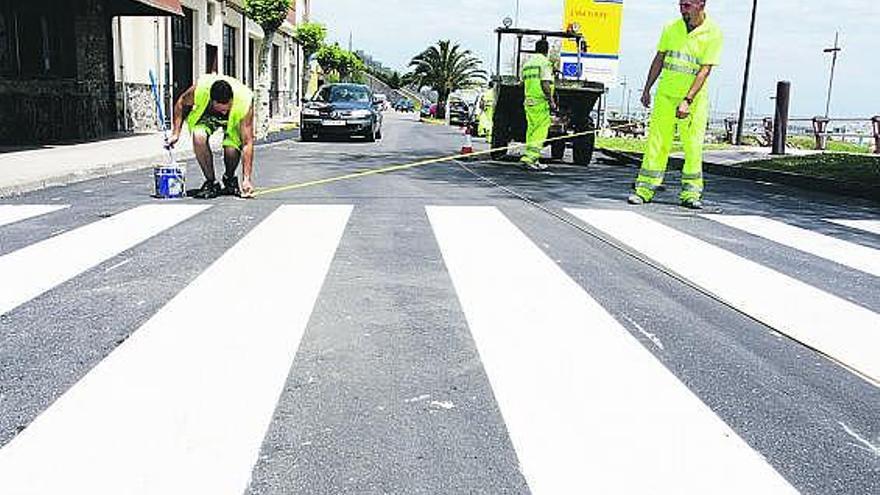 Varios trabajadores pintan un paso de peatones, ayer, en la avenida del Gayo.