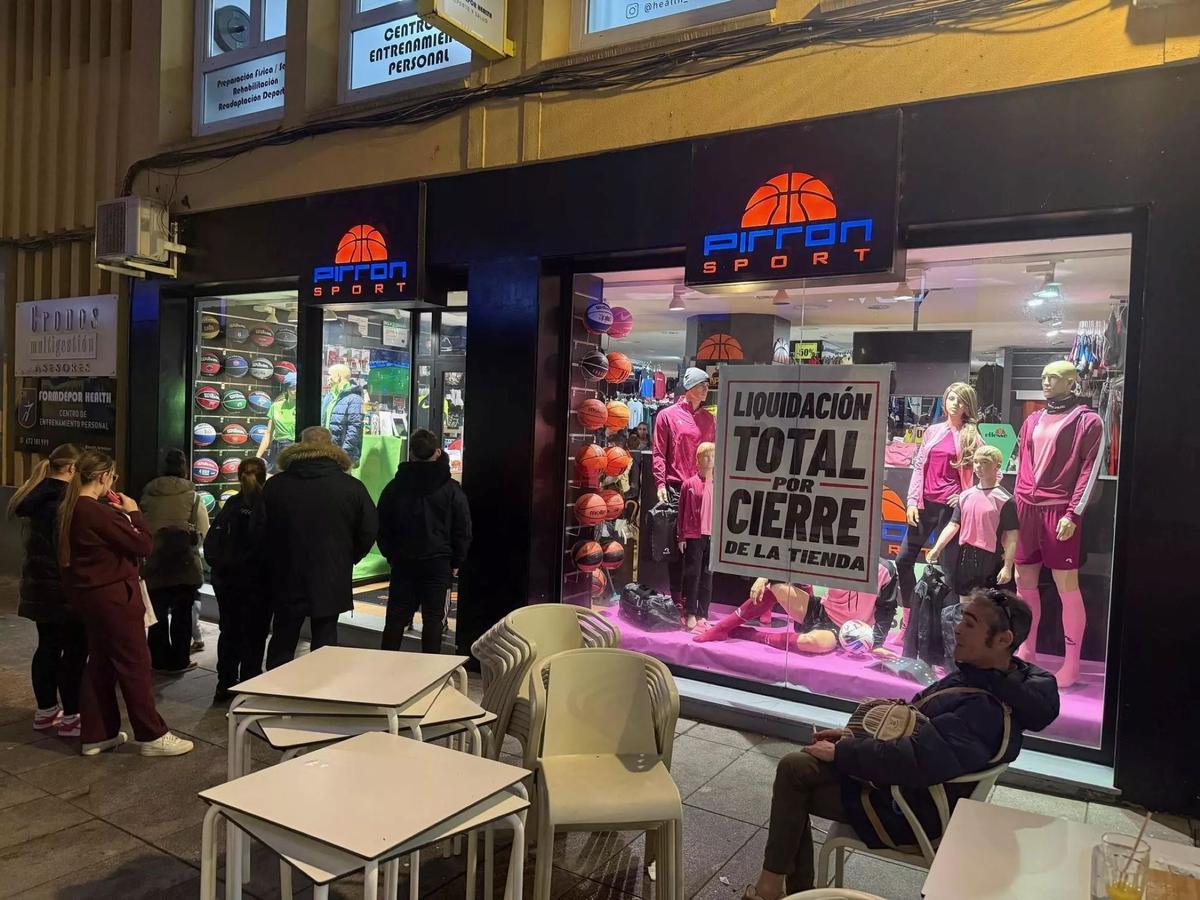 Varias personas se acercan a Pirron Sport durante la liquidación por cierre del establecimiento.