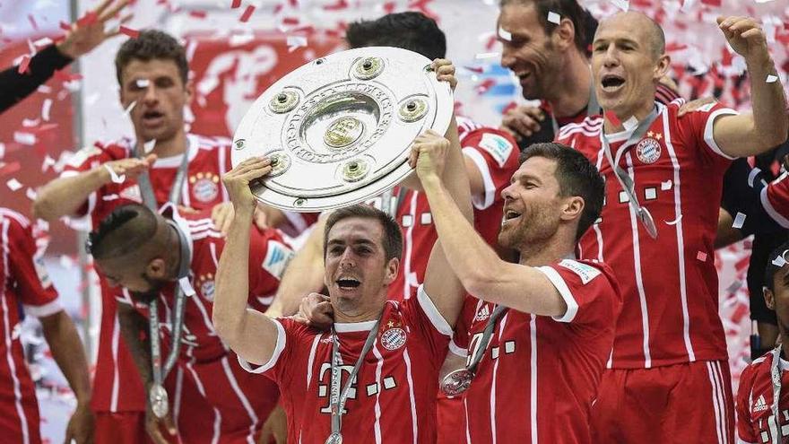 Lahm y Alonso levantan el trofeo que acredita al Bayern como campeón de Liga y que se entregó ayer. // Efe