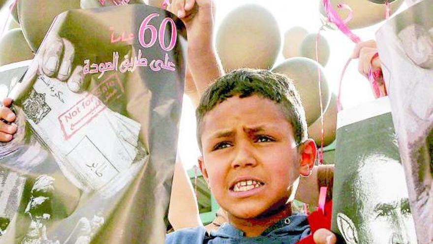 Un niño palestino, con pancartas contra Bush y globos negros durante una manifestación con motivo del «Desastre».