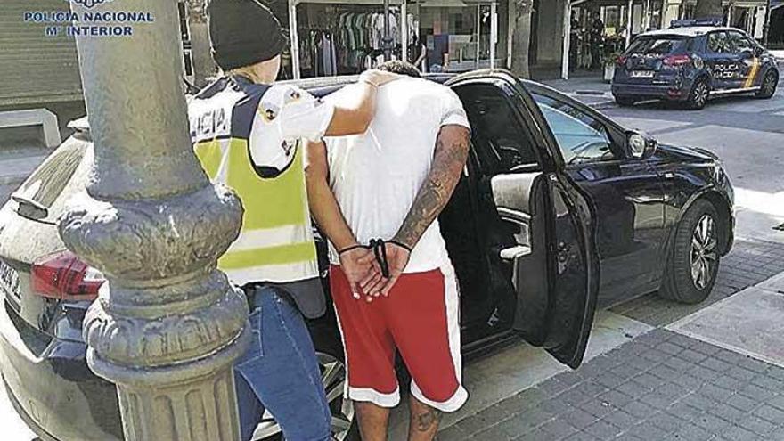 Una policía traslada a uno de los detenidos en la operación antidroga en s´Illot (Manacor).