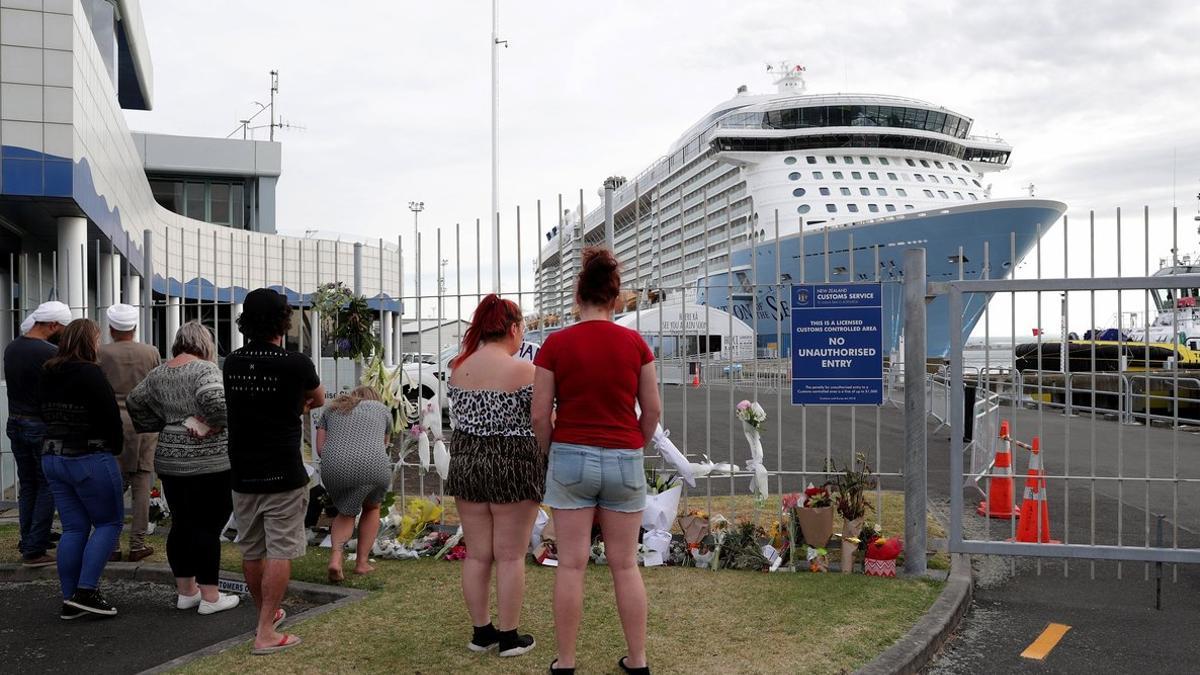 Personas acercándose a dejar flores en memoria de las víctimas