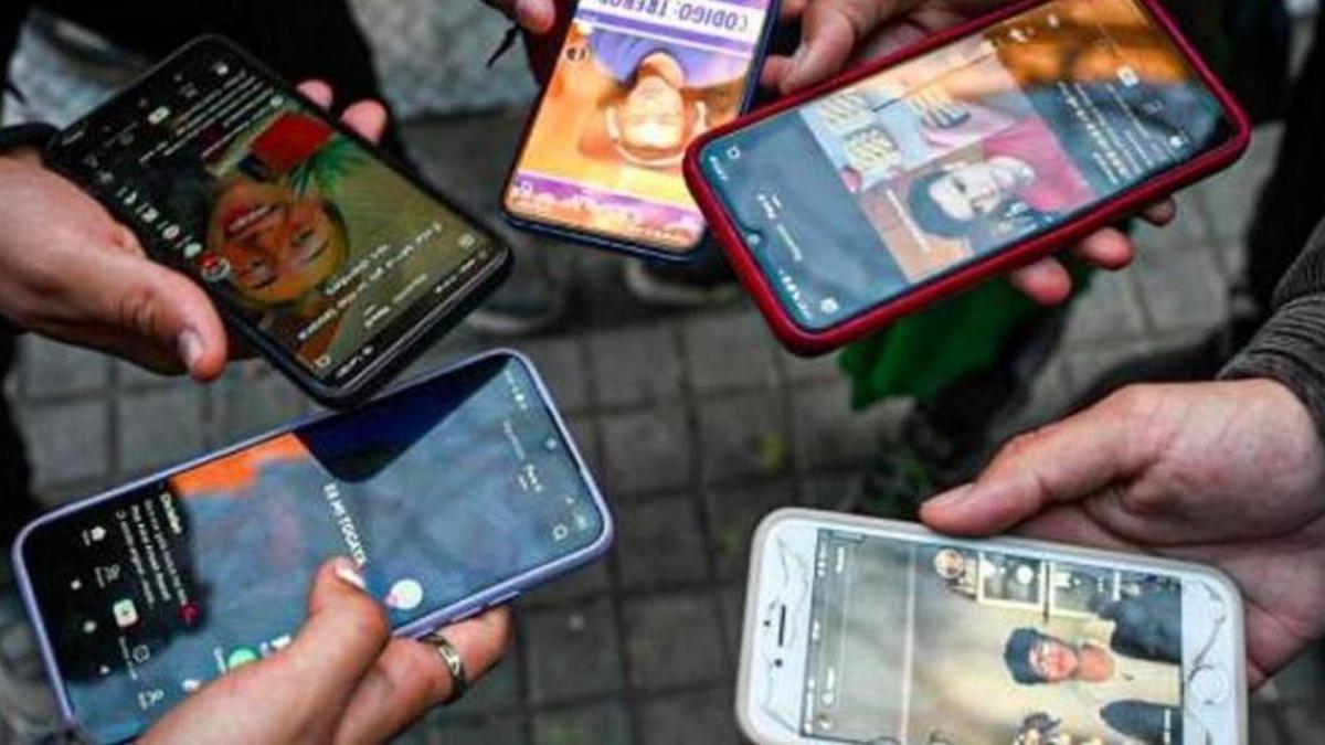 Adolescents fent ús de xarxes socials amb el mòbil en una imatge d'arxiu.