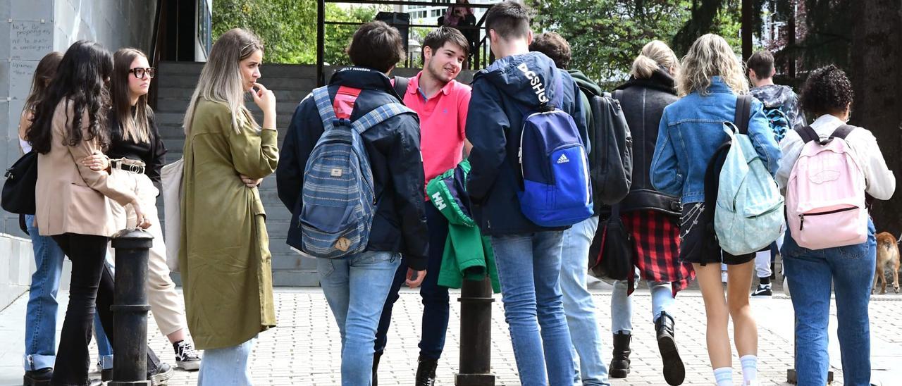 Un grupo de estudiantes charla delante de una facultad en Santiago de Compostela.