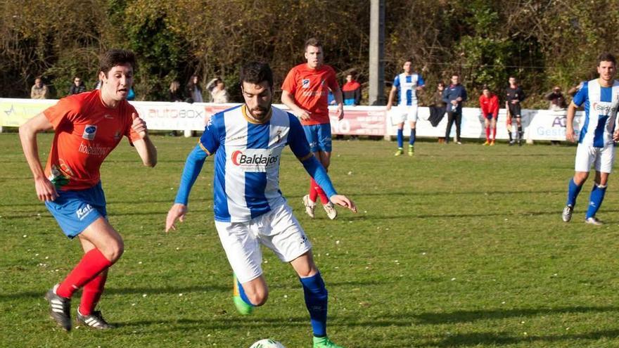 El jugador del Avilés Nacho Méndez, con el balón, perseguido por Usillos.