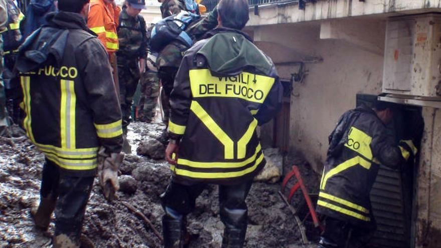 Miembros de los servicios de rescate revisan edificios afectados por las inundaciones en Giampilieri