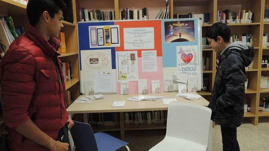 Dos alumnos observan los mensajes expuestos sobre el libro de Saint-Exupéry.