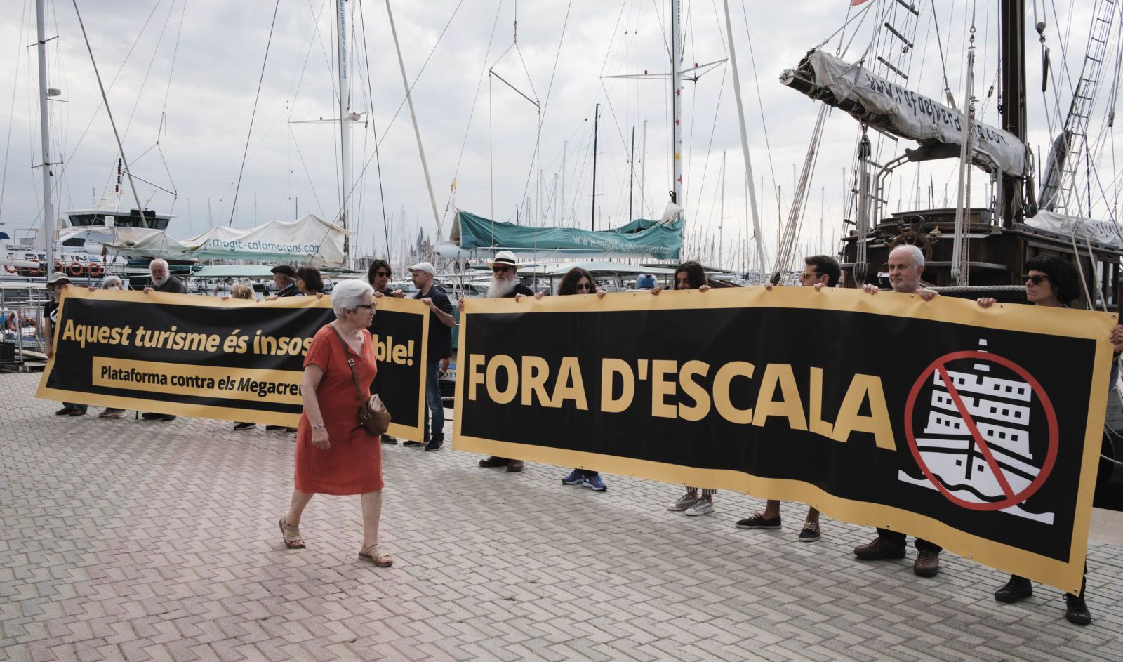 Una turista, ayer, pasando por delante de la protesta contra los megacruceros en Palma. 