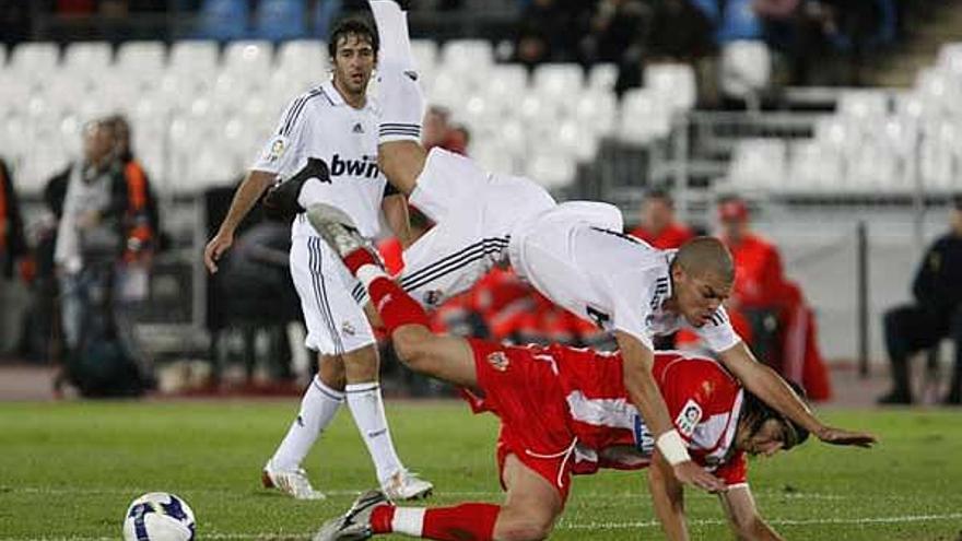 Pepe cae sobre José Manuel Flores, del Almería, en presencia de Raúl, ayer en el estadio Juegos Mediterráneos .