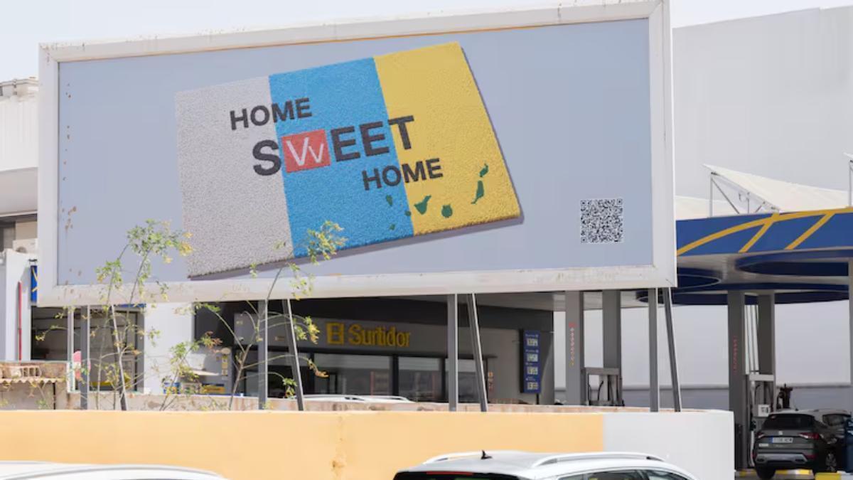 El felpudo con los colores de la bandera canaria sustituye la W por el símbolo Vv para abrir el debate sobre el derecho a la vivienda y el futuro del territorio.