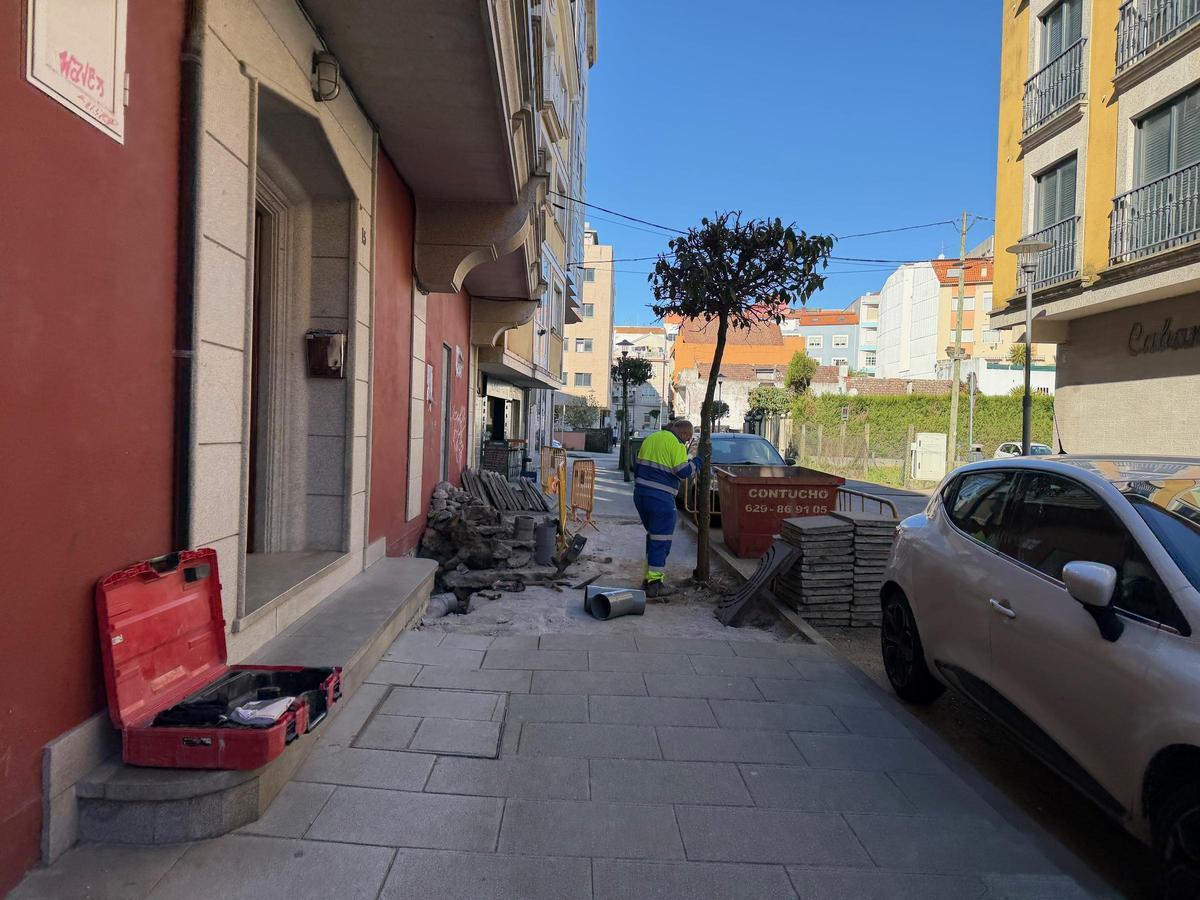 Un operario junto a la acera levantada de la calle Atranco.