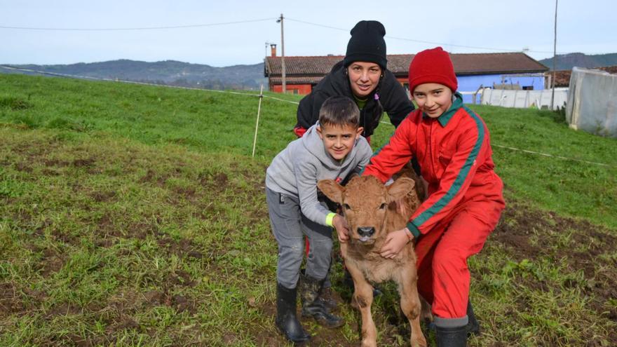 Paloma Camino Parajón, junto a sus hijos Neyla y Mateo, con uno de los xatinos de su ganadería.