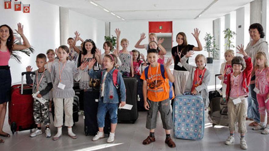 Un grupo de niños recién llegado a la isla saluda a sus familias de acogida.