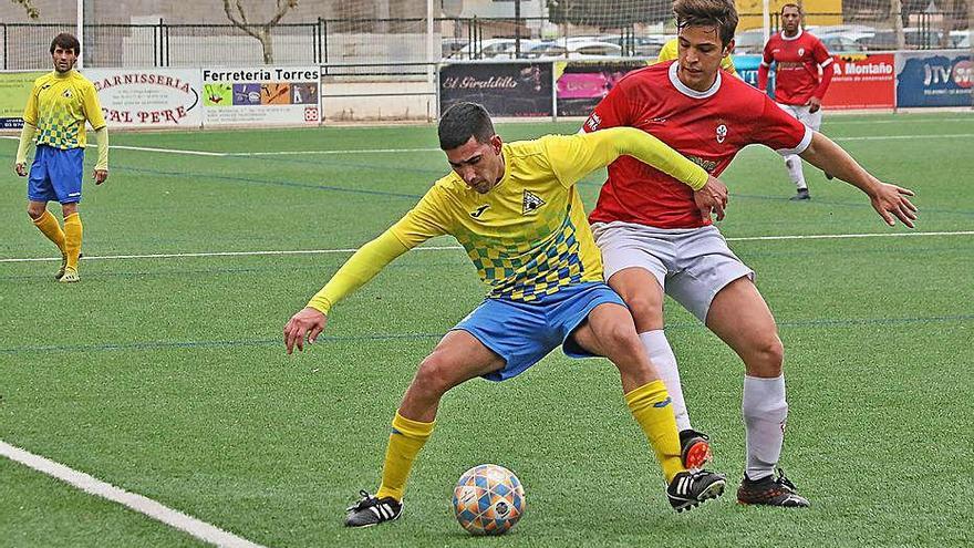 El defensa local Martín protegeix la pilota davant d&#039;un rival