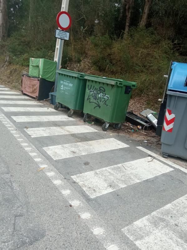 Contenedores, durante el mes de agosto en Cangas, rodeados de bolsas y botellas sin recoger.