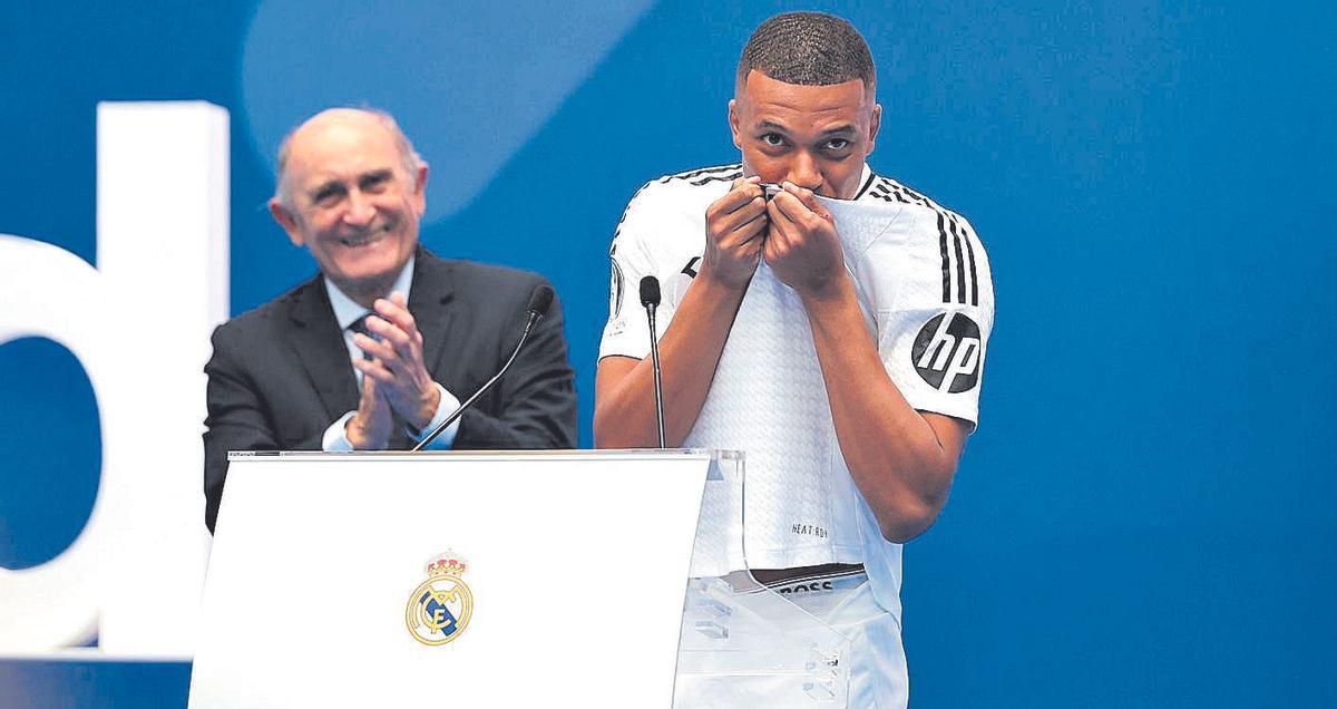 Mbappé besó el escudo del Real Madrid en repetidas ocasiones durante su presentación en el Bernabéu. 16 July 2024, Spain, Madrid: Real Madrid president Florentino Perez and new Real Madrid player Kylian Mbappe during a presentation at the Santiago Bernabeu Stadium. Photo: Isabel Infantes/PA Wire/dpa 16/07/2024 ONLY FOR USE IN SPAIN