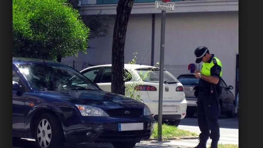 Un agente de la Policia Local imponiendo una multa por un vehículo mal aparcado.