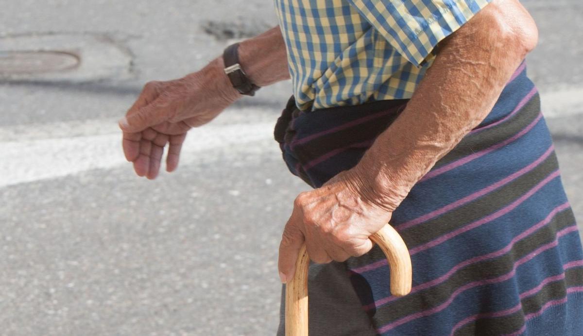 Un anciano camina agarrando un bastón. | LOZ