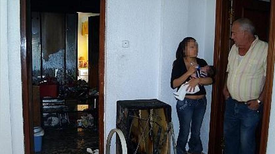 vivienda afectada. La hija de los inquilinos del piso donde se produjo el fuego ayer, junto a un vecino.