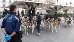 Un policía municipal de Madrid observa el cierre y recogida de una terraza.